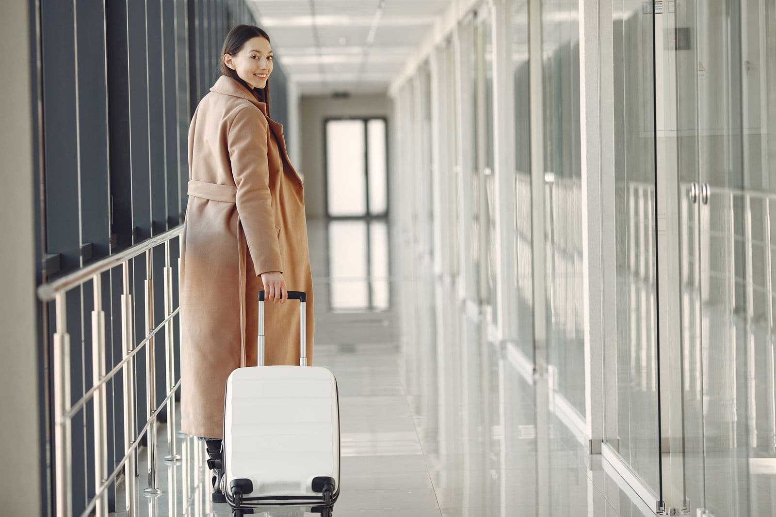 A traveler walking through an airport with a suitcase